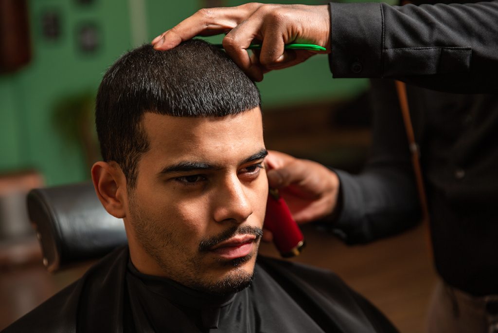 buzz cut mężczyzna w salonie fryzjerskim podczas cięcia