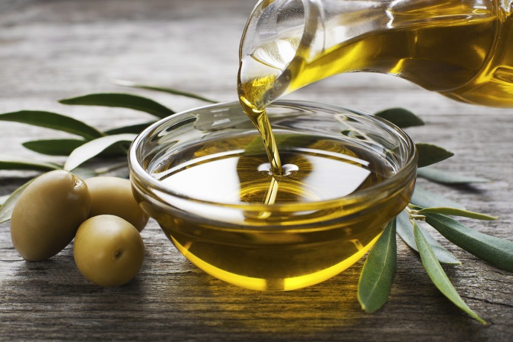 oliwa z oliwek w pielęgnacji włosów nalewanie oleju do miseczki